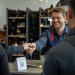 Smiling customer at a local UK tyre shop after service, with Google review stars and a QR code for leaving a review